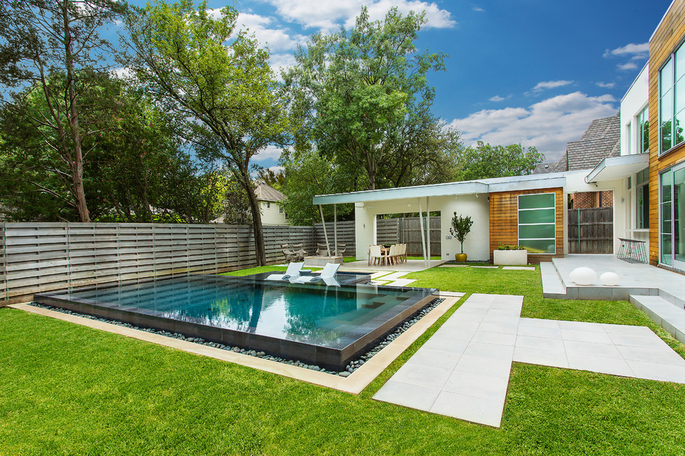 Modelo de piscinas y jacuzzis minimalistas grandes rectangulares en patio trasero con suelo de baldosas