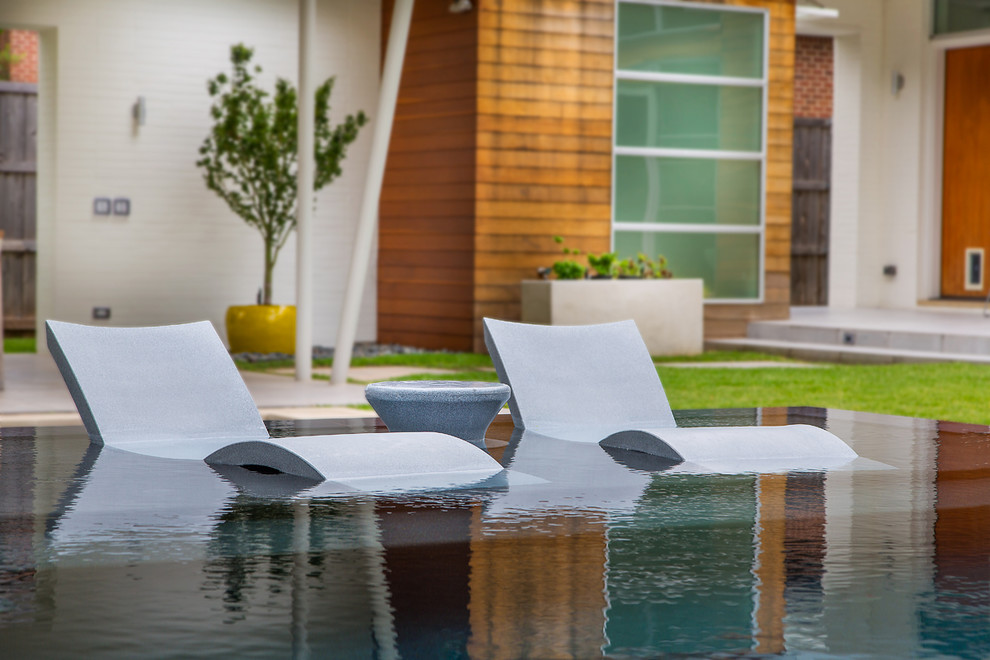 Foto de piscinas y jacuzzis minimalistas grandes rectangulares en patio trasero con suelo de baldosas