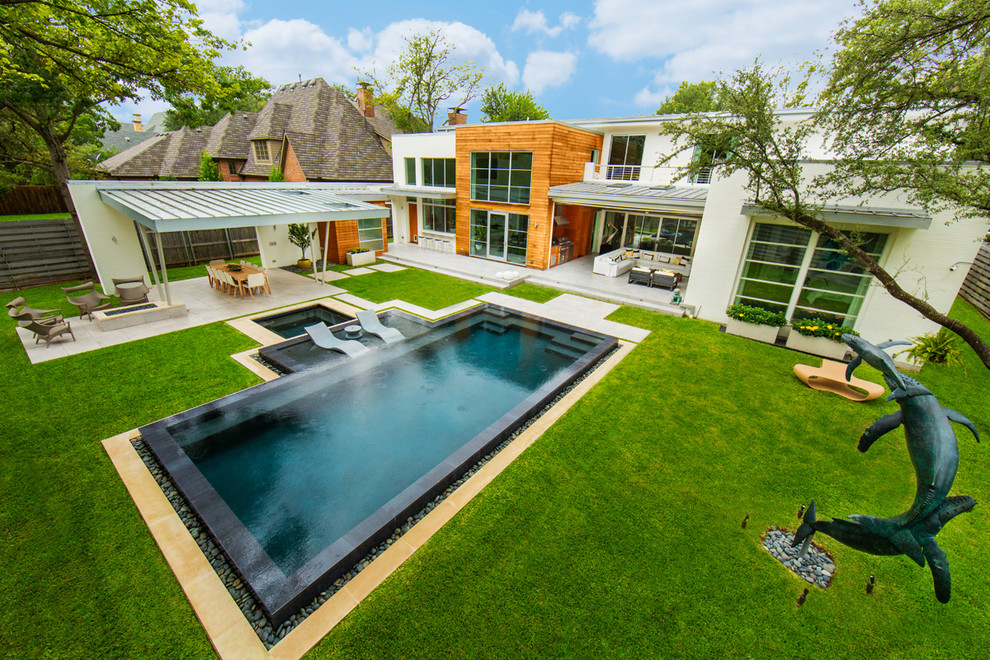Cette photo montre une grande piscine arrière moderne rectangle avec un bain bouillonnant et du carrelage.