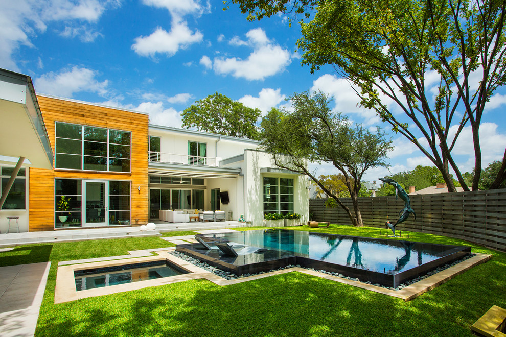 Ejemplo de piscinas y jacuzzis modernos grandes rectangulares en patio trasero con suelo de baldosas