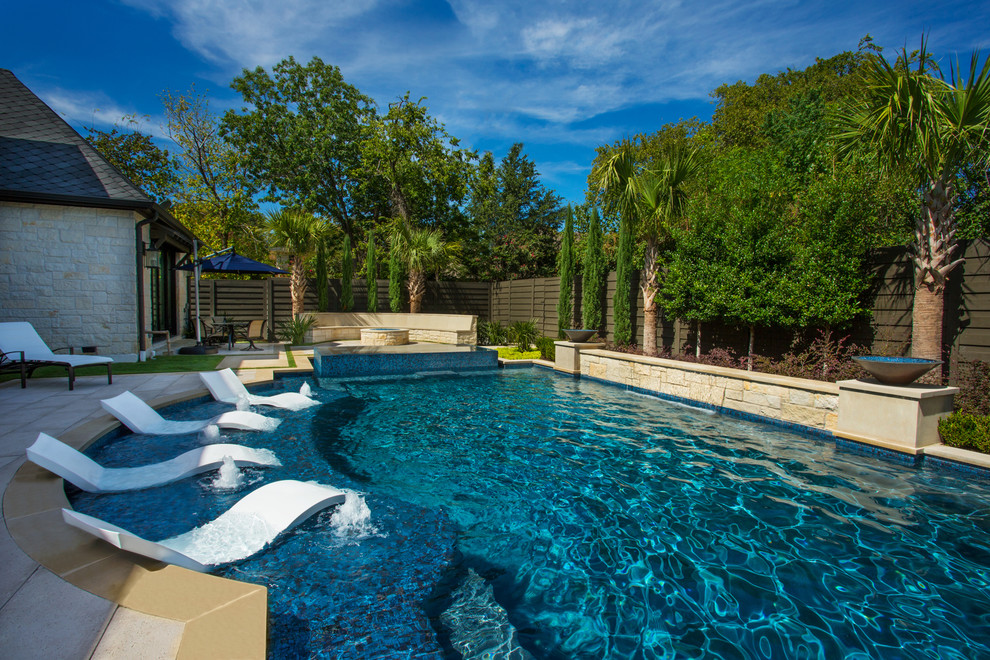 Ejemplo de piscina tradicional renovada grande a medida en patio trasero con adoquines de piedra natural