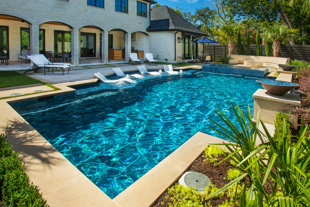 На фото: большой бассейн произвольной формы на заднем дворе в стиле неоклассика (современная классика) с покрытием из каменной брусчатки