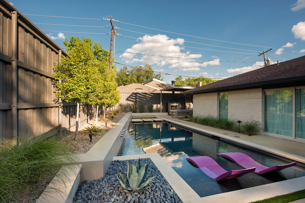 Ispirazione per una piscina minimalista personalizzata di medie dimensioni e dietro casa con lastre di cemento