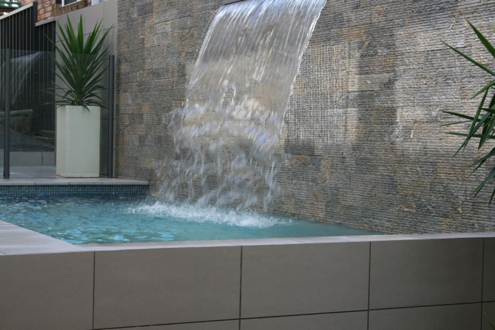 Idée de décoration pour une piscine naturelle et latérale minimaliste de taille moyenne et rectangle avec un point d'eau et du carrelage.