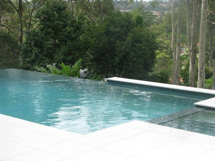 Cette image montre une piscine naturelle minimaliste de taille moyenne et rectangle avec une cour et du carrelage.
