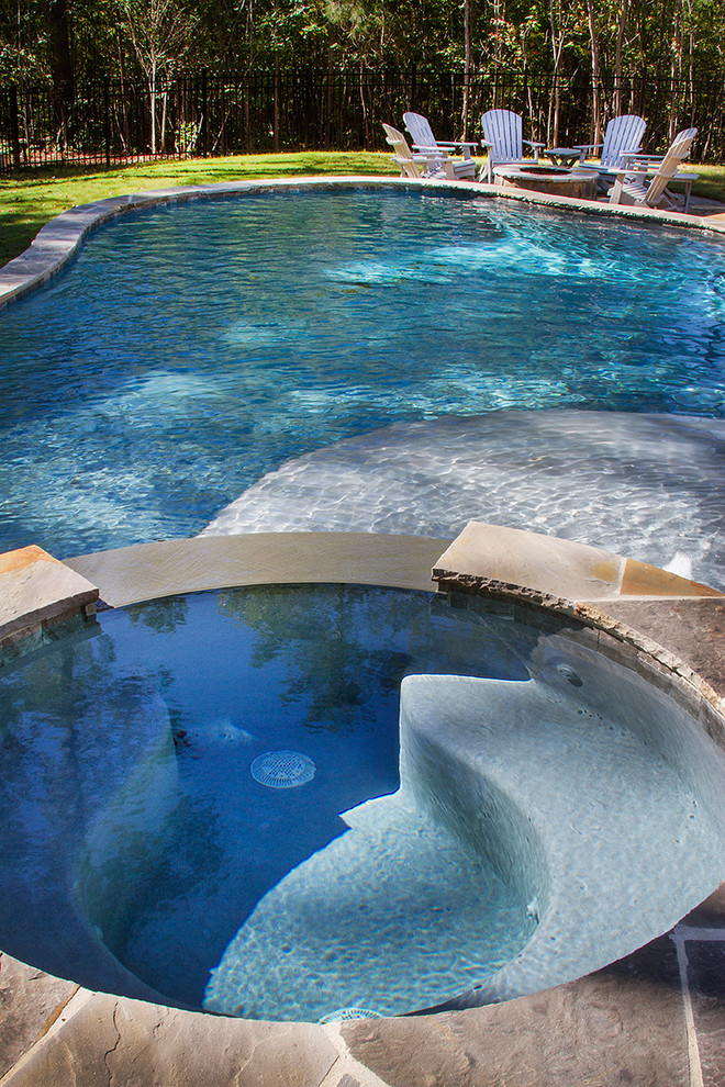 Ejemplo de piscinas y jacuzzis naturales rurales de tamaño medio a medida en patio trasero con adoquines de hormigón