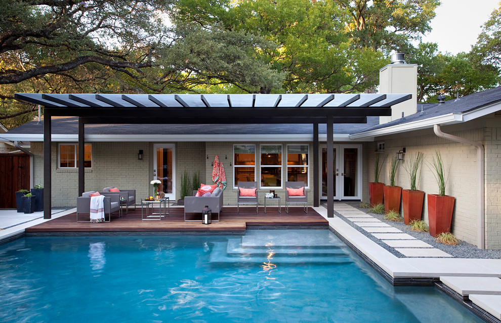 Пример оригинального дизайна: бассейн среднего размера на заднем дворе в стиле модернизм с настилом
