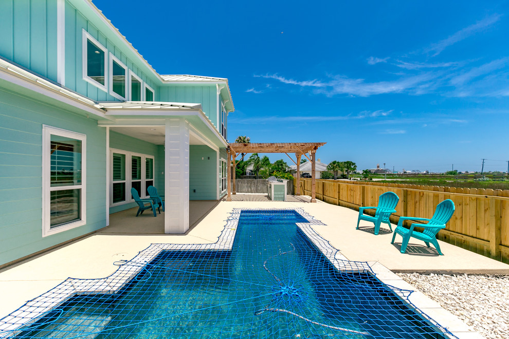 Idee per una piscina stile marinaro personalizzata di medie dimensioni e dietro casa con lastre di cemento