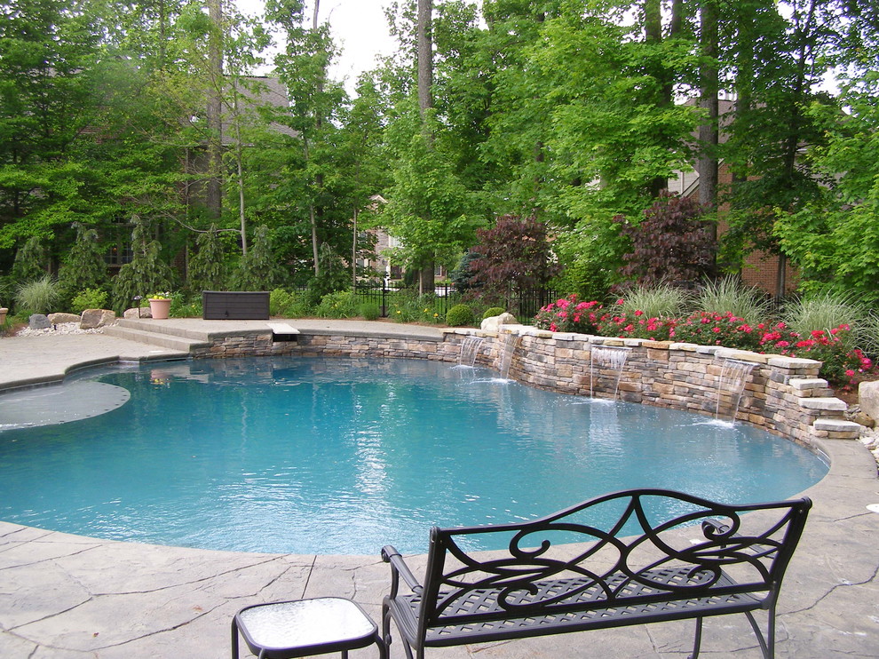 Immagine di una piscina fuori terra chic dietro casa con una vasca idromassaggio e pavimentazioni in pietra naturale