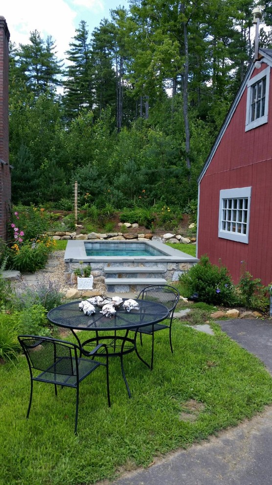 Cette image montre une petite piscine naturelle traditionnelle rectangle avec un bain bouillonnant, une cour et des pavés en pierre naturelle.