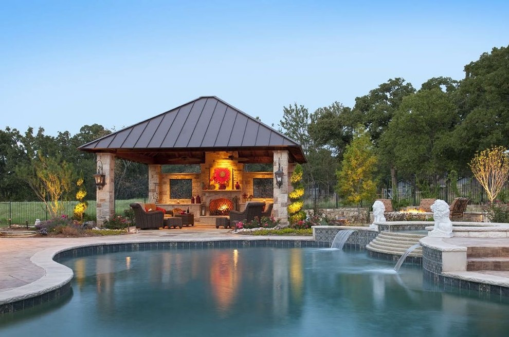 Ejemplo de piscina clásica grande en patio trasero con adoquines de piedra natural