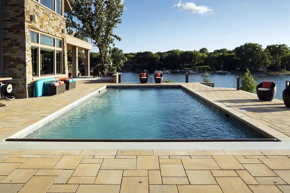 Esempio di una grande piscina monocorsia rettangolare dietro casa con pavimentazioni in pietra naturale