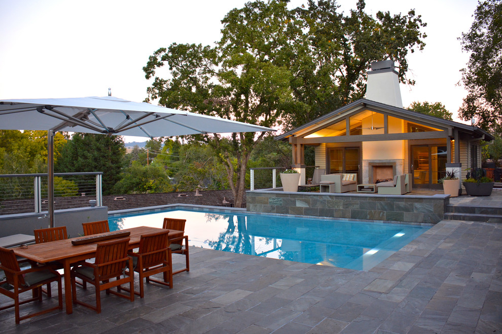 Foto de casa de la piscina y piscina alargada contemporánea grande rectangular en patio trasero con adoquines de piedra natural