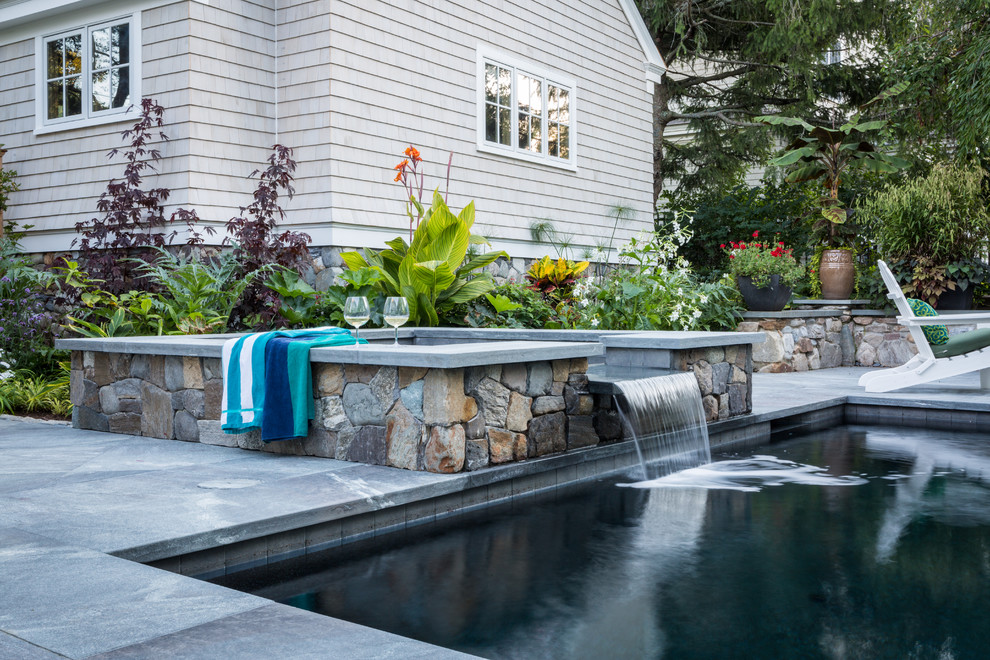 Photo of a small classic side rectangular lengths hot tub in Portland Maine with natural stone paving.