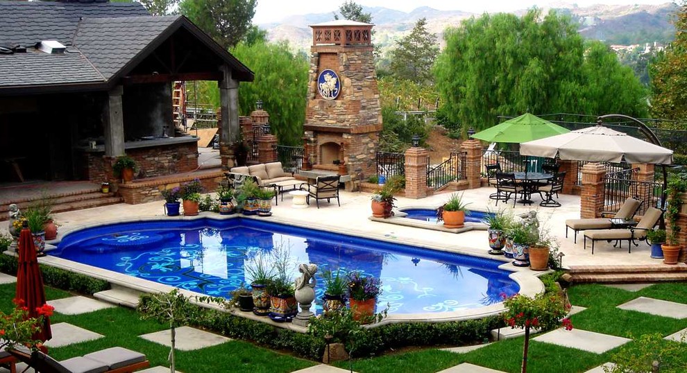 На фото: большой наземный бассейн произвольной формы на заднем дворе в средиземноморском стиле с домиком у бассейна и покрытием из каменной брусчатки с