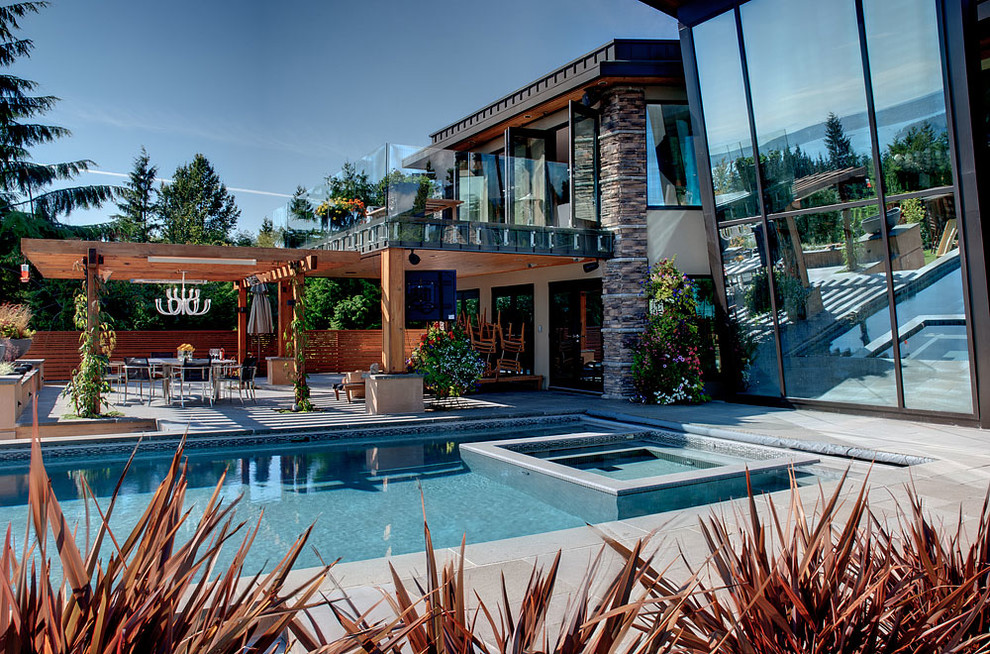 Идея дизайна: большой прямоугольный бассейн-инфинити на заднем дворе в стиле модернизм с джакузи и покрытием из плитки