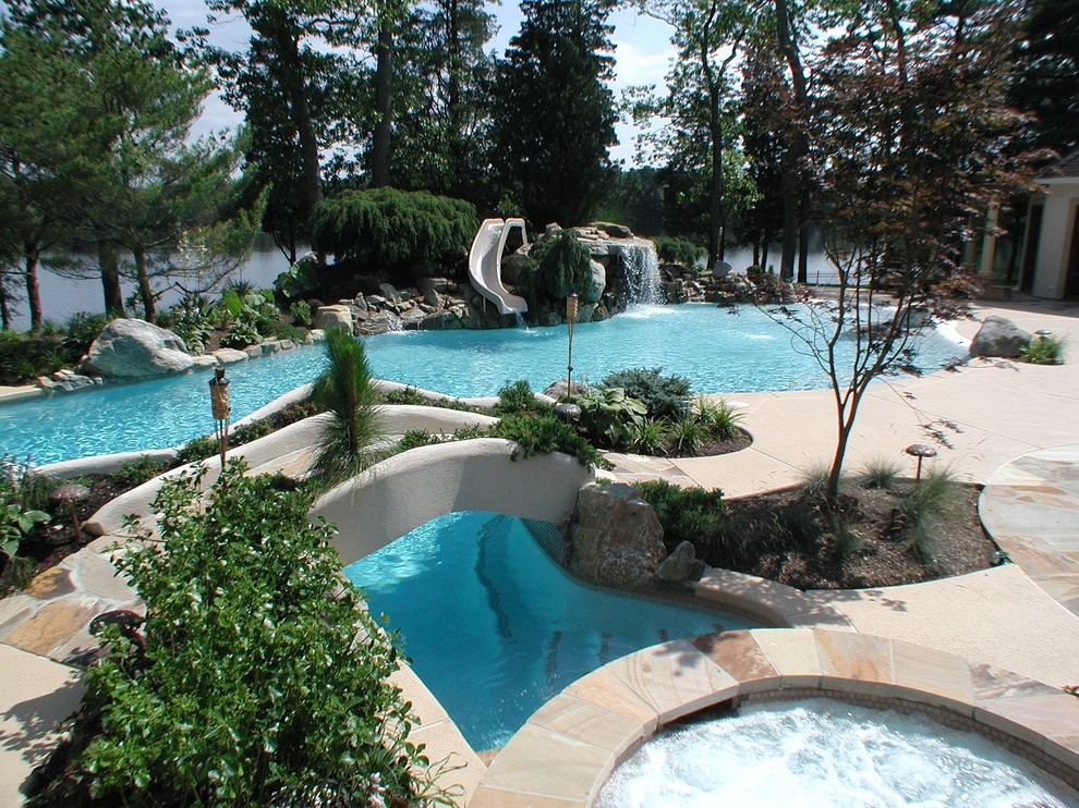 Hot tub - large mediterranean backyard custom-shaped and concrete natural hot tub idea in New York