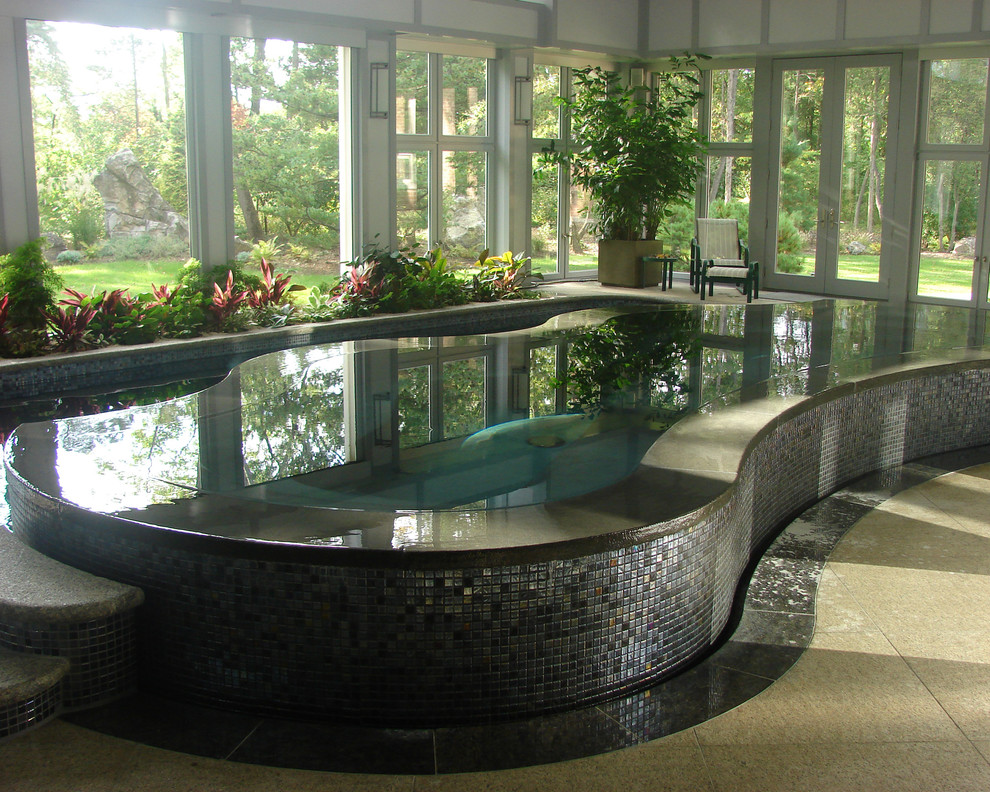 Exemple d'une grande piscine intérieure à débordement tendance en forme de haricot avec un bain bouillonnant et des pavés en pierre naturelle.