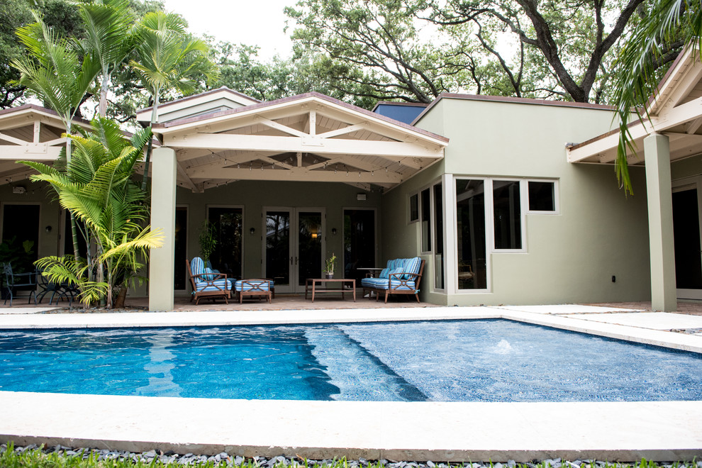Diseño de casa de la piscina y piscina alargada tradicional renovada grande rectangular en patio trasero con adoquines de hormigón