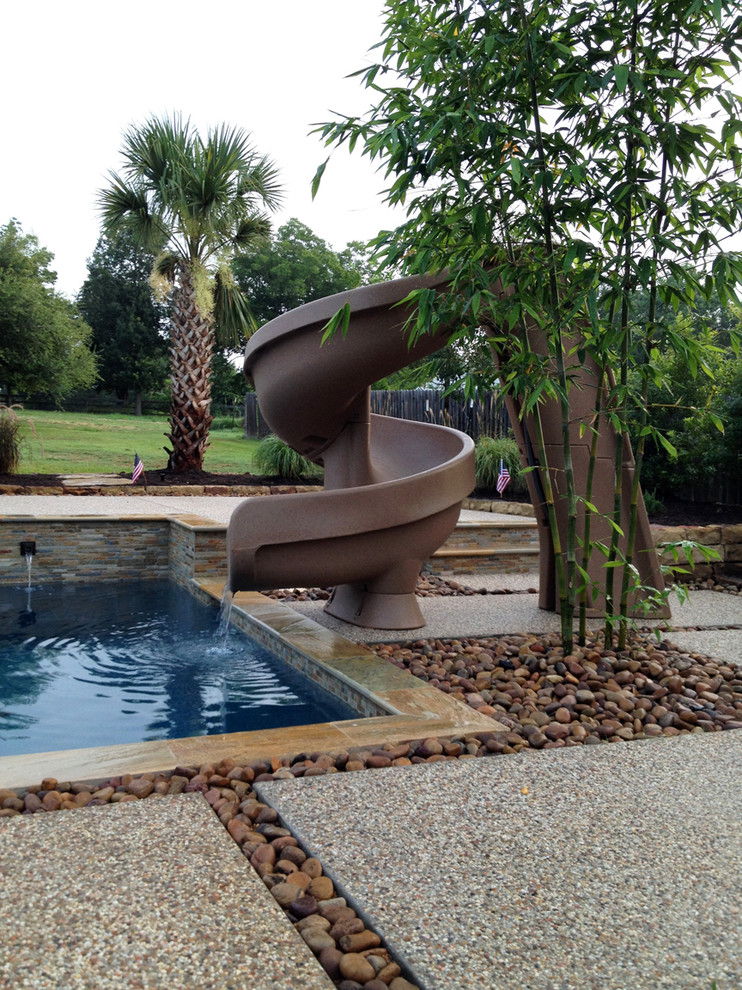 Источник вдохновения для домашнего уюта: большой бассейн произвольной формы на заднем дворе в стиле рустика с водной горкой и покрытием из бетонных плит