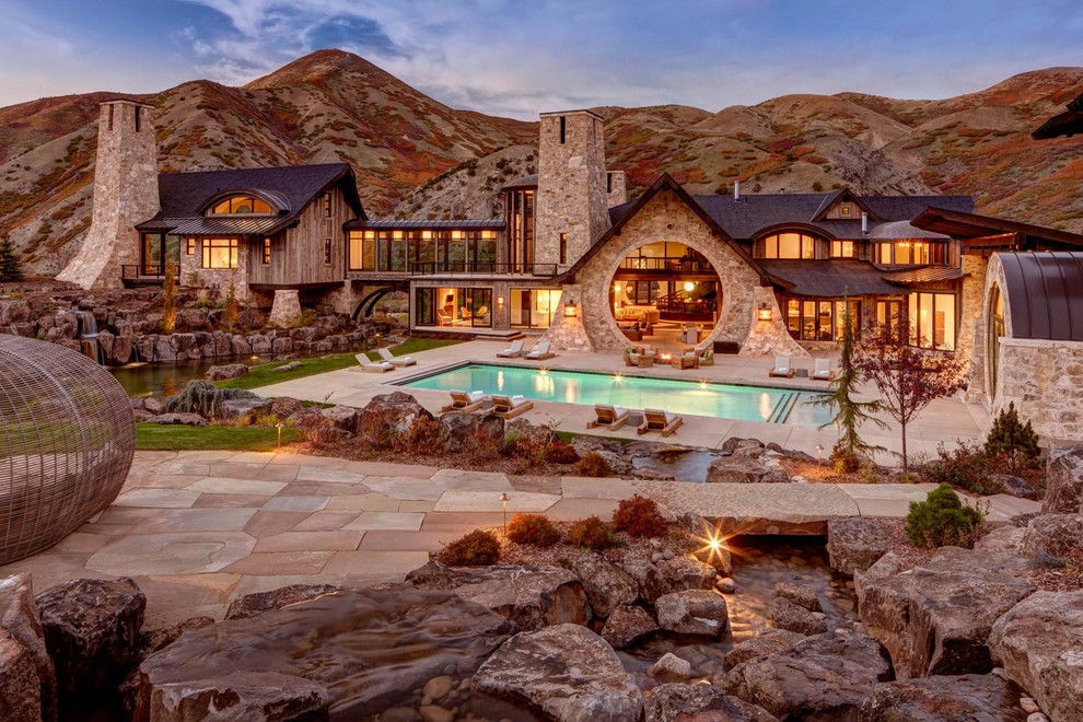Example of a large mountain style front yard stone and rectangular lap pool design in Other