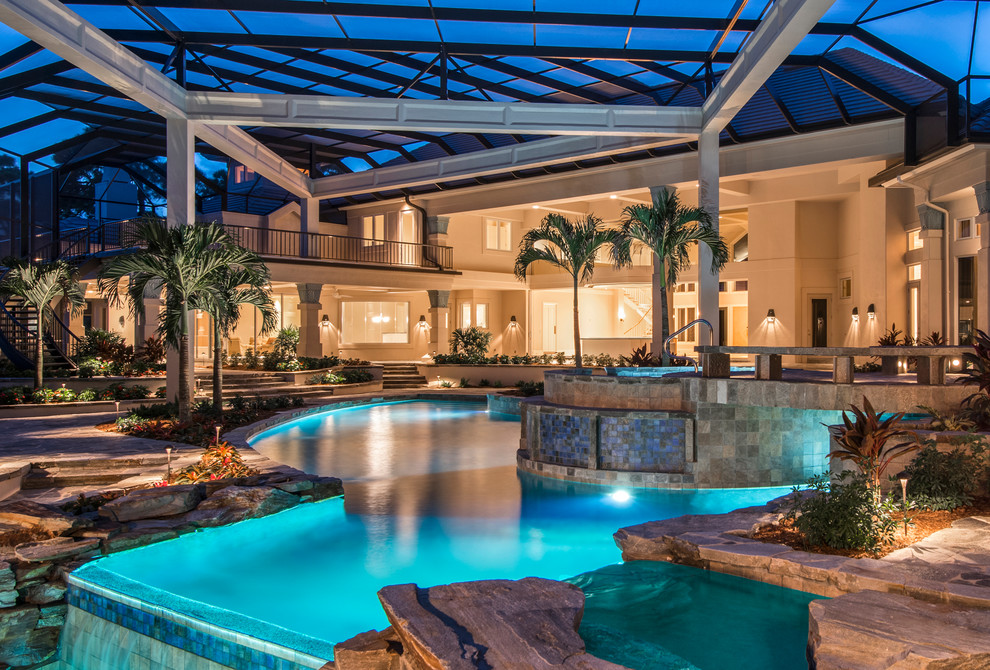 Foto di una grande piscina naturale design personalizzata dietro casa con fontane e pavimentazioni in pietra naturale