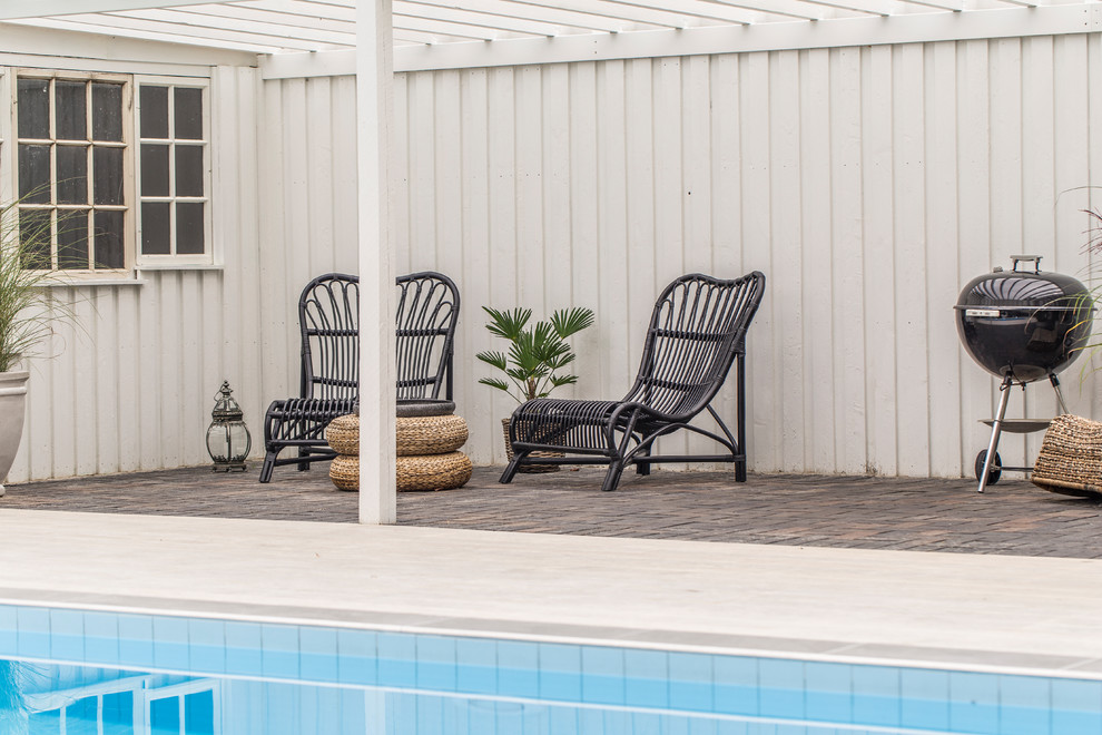 Imagen de piscina natural clásica renovada grande rectangular en patio trasero con entablado
