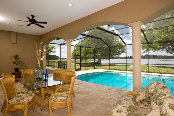 Foto di una grande piscina monocorsia costiera rettangolare dietro casa con una dépendance a bordo piscina e piastrelle