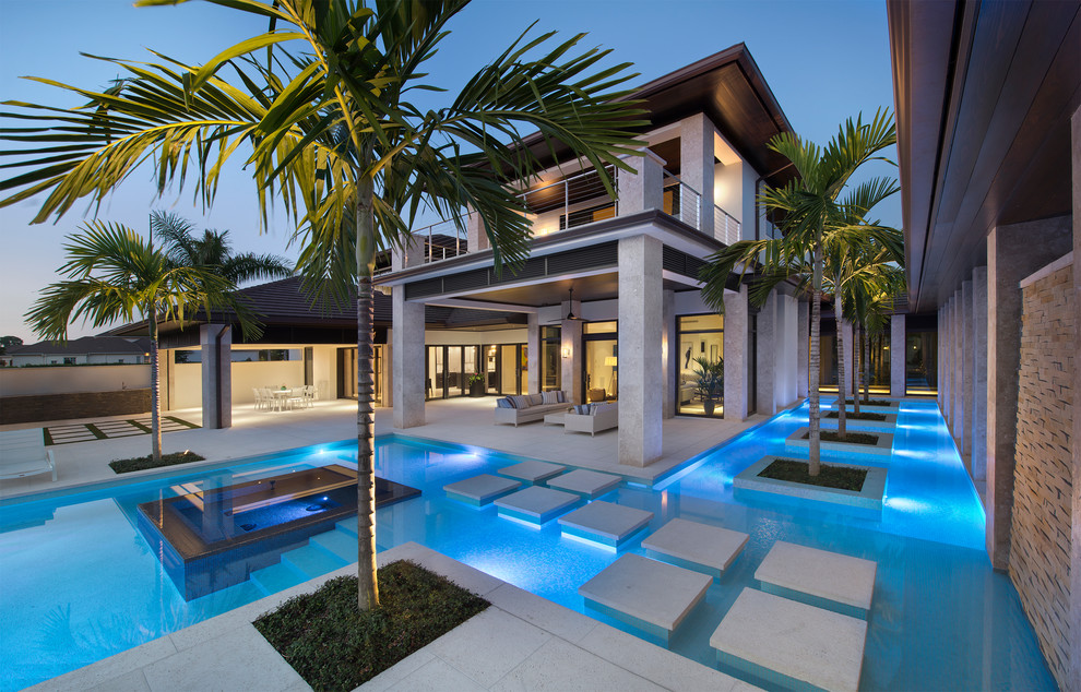Ispirazione per una piscina tropicale personalizzata dietro casa con cemento stampato