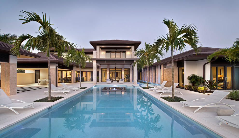 Example of a transitional backyard rectangular pool design in Miami