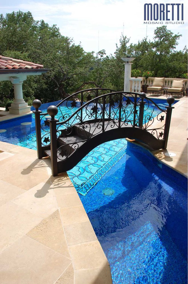 Aménagement d'un grand Abris de piscine et pool houses arrière méditerranéen sur mesure avec des pavés en pierre naturelle.