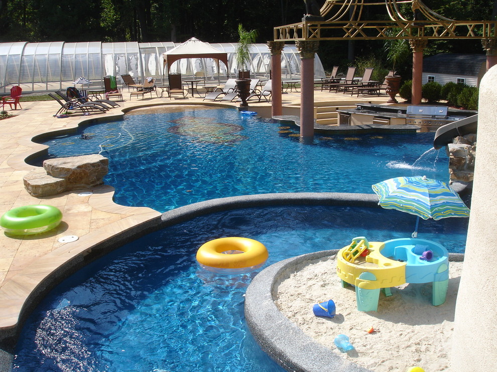 Ispirazione per una grande piscina minimal personalizzata dietro casa con un acquascivolo e pavimentazioni in pietra naturale