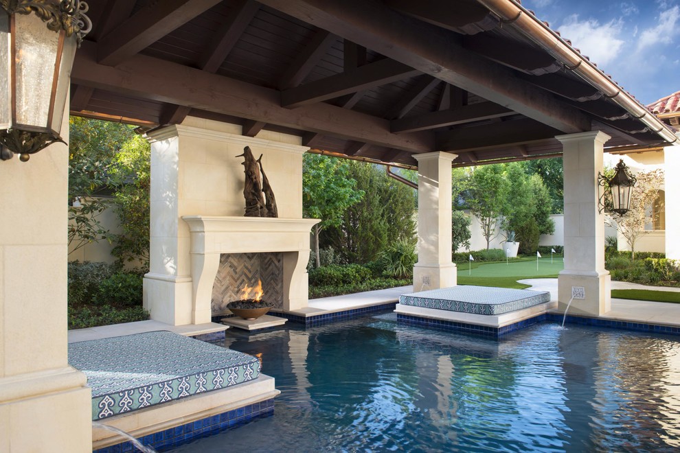 Diseño de piscina con fuente mediterránea rectangular en patio trasero con adoquines de hormigón