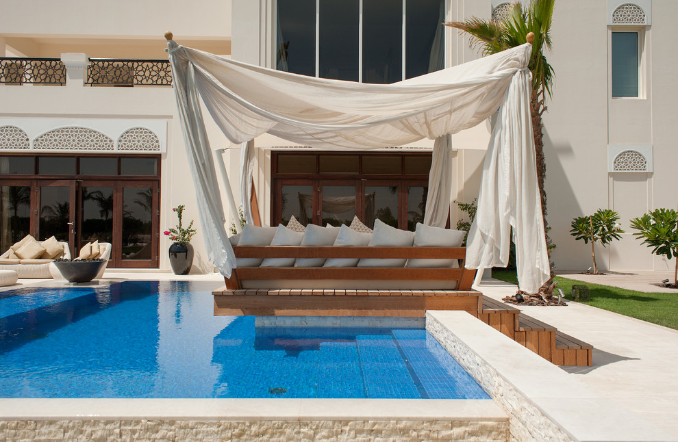 Modelo de piscina mediterránea en forma de L en patio trasero