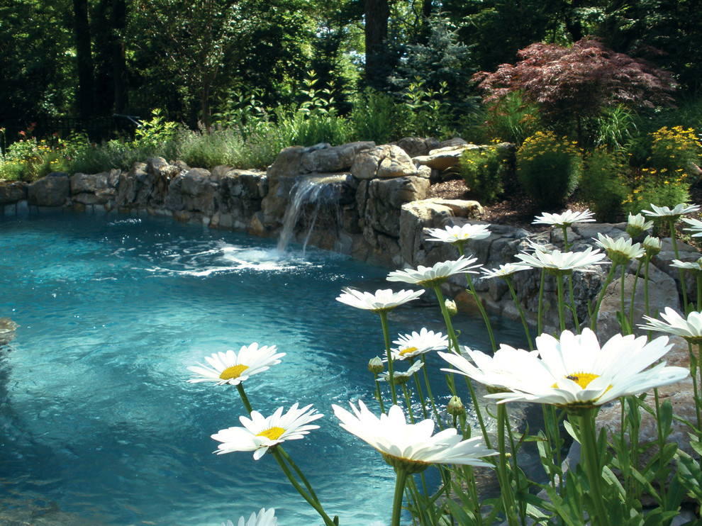 Idee per una piscina tradizionale a "C" di medie dimensioni e dietro casa con pavimentazioni in pietra naturale e fontane