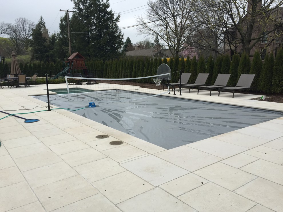 Geräumiger Klassischer Pool hinter dem Haus mit Natursteinplatten in Detroit