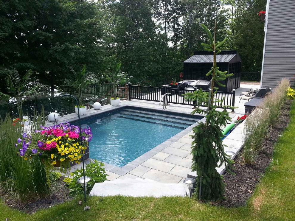 Moderner Pool hinter dem Haus in rechteckiger Form mit Pflastersteinen in Montreal