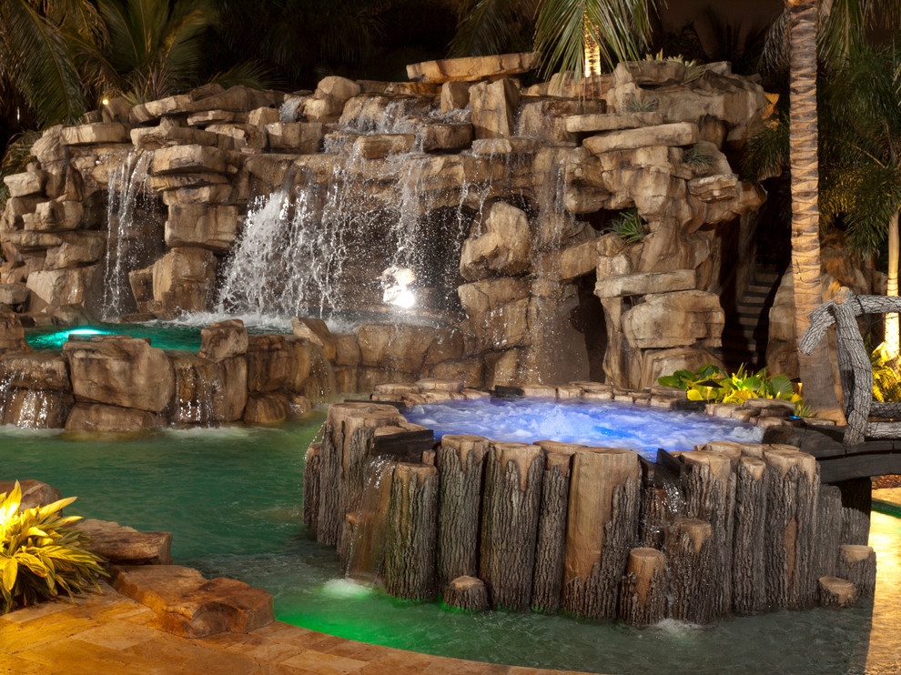 Exemple d'un grand couloir de nage arrière montagne sur mesure avec des pavés en pierre naturelle et un bain bouillonnant.