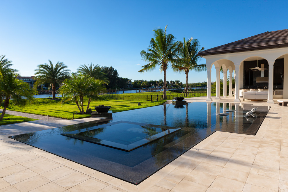 Example of a large trendy backyard tile and custom-shaped infinity hot tub design in Miami