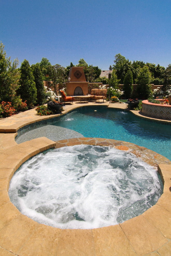 Idee per una piscina monocorsia mediterranea a "C" di medie dimensioni e dietro casa con una vasca idromassaggio e pavimentazioni in pietra naturale