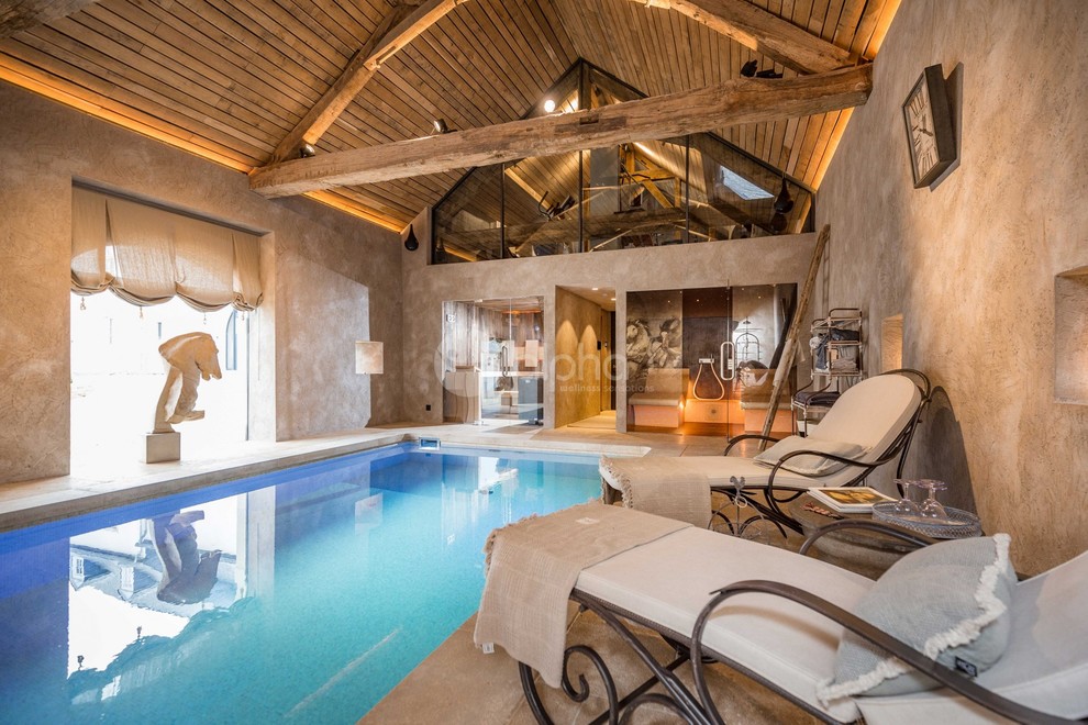 Ejemplo de piscinas y jacuzzis alargados rústicos grandes interiores y rectangulares con adoquines de piedra natural
