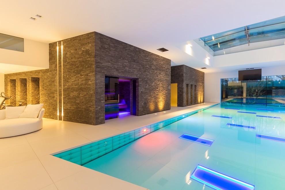 Ejemplo de piscinas y jacuzzis alargados actuales extra grandes interiores y rectangulares con adoquines de piedra natural
