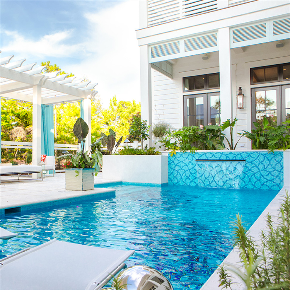 Large contemporary back rectangular lengths swimming pool in Miami with a water feature and concrete slabs.