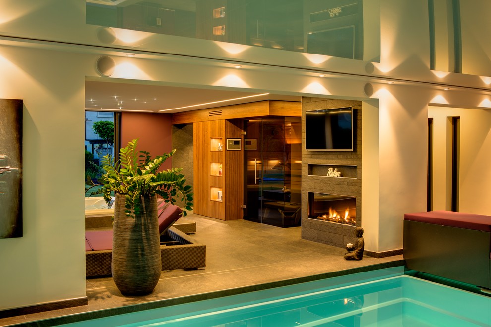 Design ideas for a contemporary indoor swimming pool in Other with a pool house.