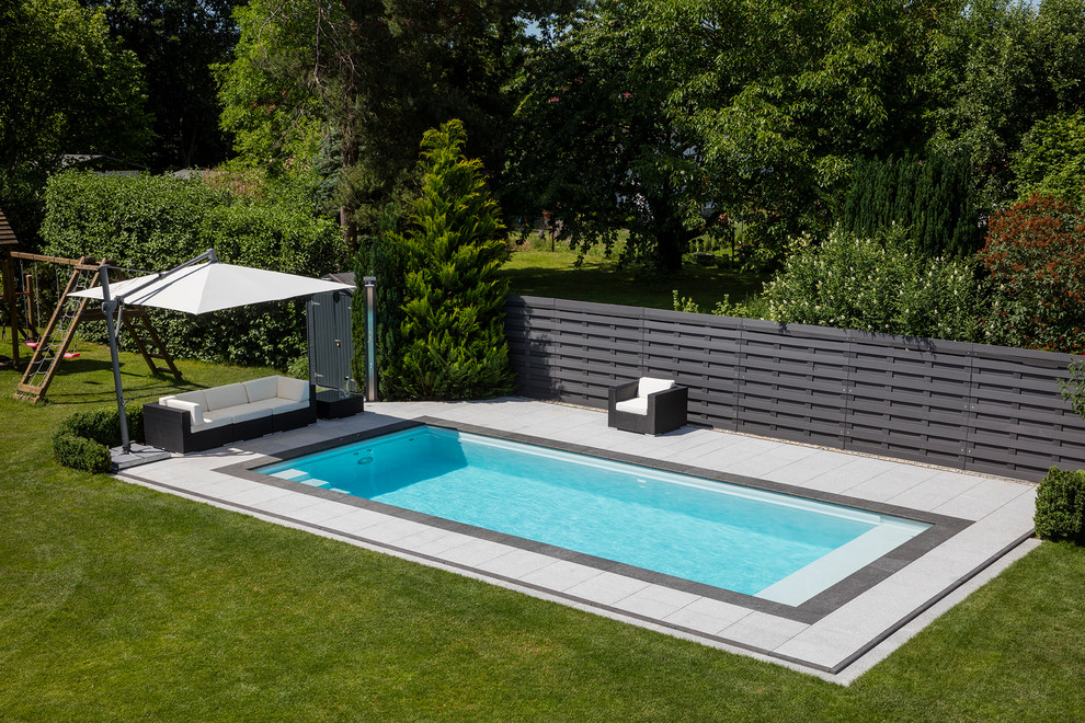 Immagine di una piscina monocorsia moderna rettangolare di medie dimensioni con pavimentazioni in pietra naturale