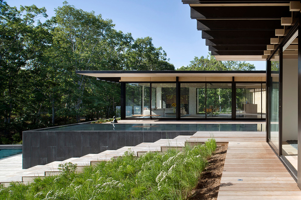 Imagen de piscina minimalista rectangular en patio trasero con entablado