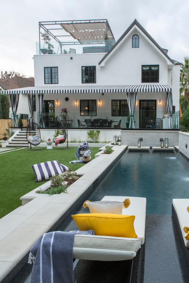 Eklektisches Sportbecken hinter dem Haus in rechteckiger Form mit Wasserspiel in Los Angeles
