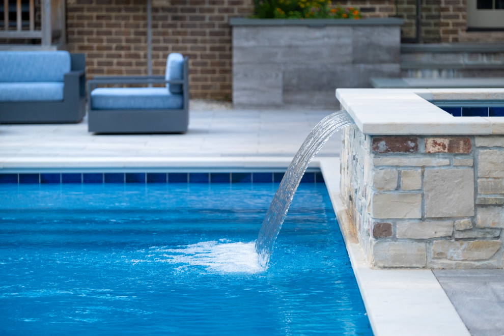 Ispirazione per una piscina monocorsia chic rettangolare di medie dimensioni e dietro casa con paesaggistica bordo piscina e pavimentazioni in pietra naturale