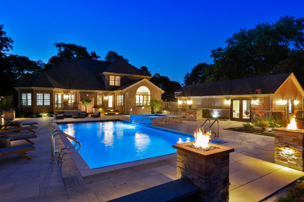 Immagine di una piscina monocorsia tradizionale rettangolare di medie dimensioni e dietro casa con paesaggistica bordo piscina e pavimentazioni in pietra naturale