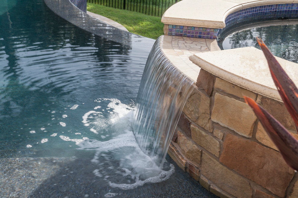 Großer Klassischer Infinity-Pool hinter dem Haus in individueller Form mit Wasserspiel und Natursteinplatten in Tampa